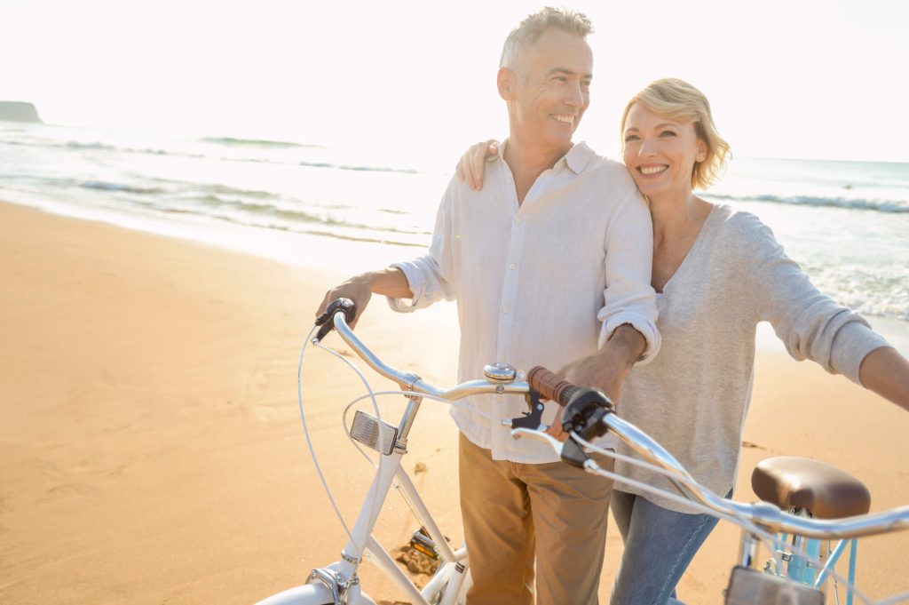 Couple riding bikes on the beach